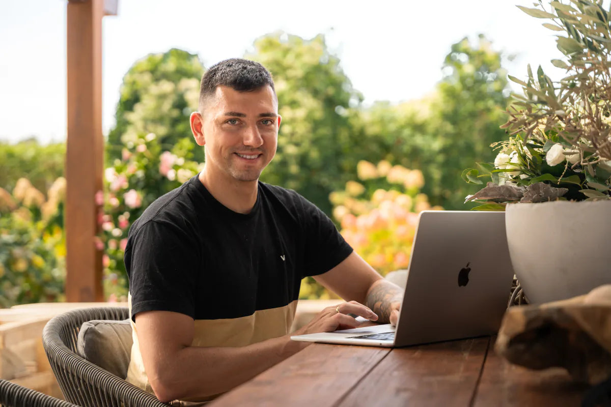 Pablo sitzt auf der Terrasse am Laptop